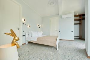 a white bedroom with a bed and a lamp at Панорамная квартира на первой линии моря Skyline Resort, Becici, Budva in Becici +13 photos