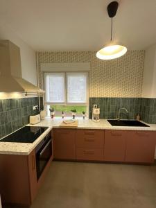 a kitchen with a sink and a stove at Appartement rez-de-chaussée de chaussée entre ville et plage in Dunkerque +8 photos