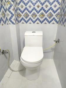 a bathroom with a toilet with a hose at Vasu Vijay Stays in Udaipur