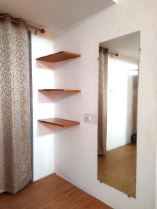a mirror on a wall with shelves and a window at Vasu Vijay Stays in Udaipur