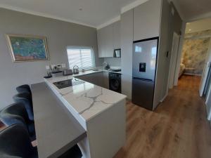 a kitchen with a white counter and a refrigerator at Mouille Point Seafront Cottage in Cape Town +13 photos