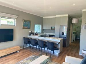 a kitchen with a counter and chairs in a room at Mouille Point Seafront Cottage in Cape Town