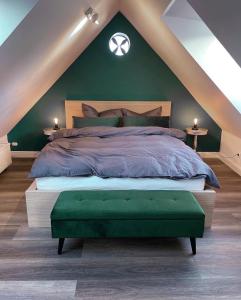 a bedroom with a large bed with a green wall at Pauerhof Ferienwohnungen in Bad Nenndorf