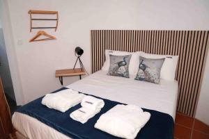 a bedroom with a bed with towels on it at Moinho da Barragem de Montargil in Montargil