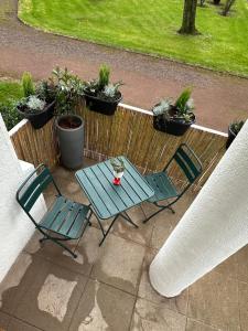 a patio with two chairs and a table and potted plants at Appartement rez-de-chaussée de chaussée entre ville et plage in Dunkerque