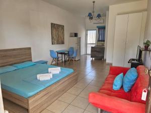 a bedroom with a bed and a red couch at Sea Apartments in Larnaca