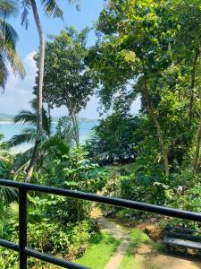 a view of the ocean from a balcony with a bench at Talalla Wonder View in Talalla South