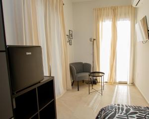 Un dormitorio con un televisor y una silla y una ventana. en Porta Nuova Suite & Rooms city center, en Palermo