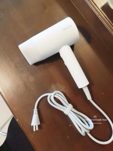 a white lamp on a desk with a cord at White Cloud Family Suite in Hat Yai