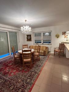 a dining room and living room with a table and chairs at Nicoles Niedschlösschen in Rehlingen-Siersburg +6 photos