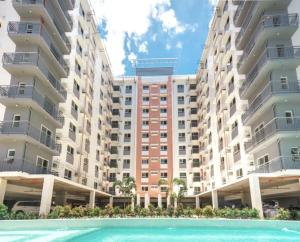 a large apartment building with a swimming pool in front of it at Mivesa Garden Residences Lahug in Cebu City