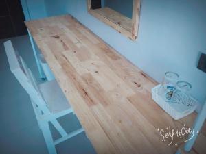 a wooden table with a chair and a desk with a shelf at Rinrada Loft Resident in Chiang Mai