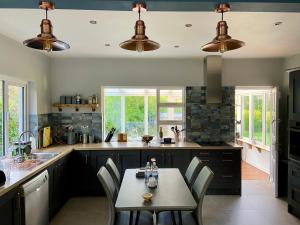 a kitchen with a table and chairs in it at Gorgeous bungalow in Faithlegg, County Waterford in Stronghowʼs Bridge +10 photos