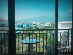 einen Balkon mit einem Tisch und Stadtblick in der Unterkunft Rinrada Loft Resident in Chiang Mai