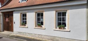 a building with three windows with potted plants on it at Ferienhaus an der KIostermauer in Speyer +13 photos