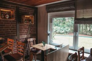 a dining room with a table and a large window at Hillmers Hoff PensionRestaurant in Undeloh