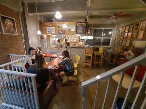 a group of people sitting at a table in a restaurant at Shelter Hostel Malang in Malang