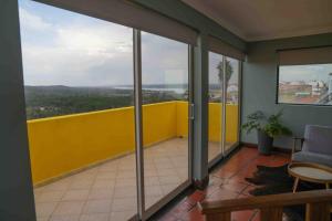 a balcony with sliding glass doors and a yellow wall at Lake View House _ Montargil in Montargil