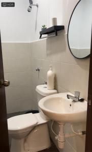 a bathroom with a sink and a toilet and a mirror at Azzahra Homestay Scientex Kundang Jaya Rawang in Pengkalan Kundang +2 photos