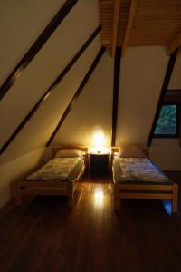 バイナ・バシュタにあるApartmani Novakovicのベッド2台と照明のある屋根裏部屋