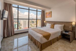Postel nebo postele na pokoji v ubytování Golden Tulip Dar Es Salaam City Center Hotel + 37 fotografií