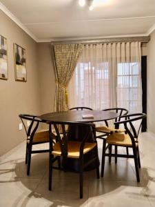 a dining room with a table and chairs and a window at Pistachio villa in Durban +18 photos