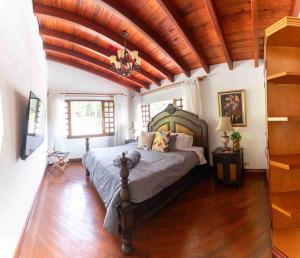 a bedroom with a large bed with a wooden ceiling at Autenthico Sajonia Hotel Aeropuerto in Rionegro +113 photos