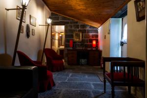 Una sala de estar con sillas rojas y una chimenea. en Casa Villa Garden, en Ponta Delgada