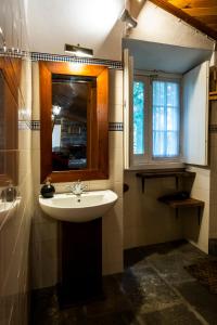 a bathroom with a sink and a mirror and a window at Casa Villa Garden in Ponta Delgada