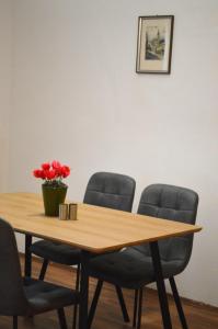 a conference room table with four chairs and a vase with red flowers at Gemütliche Ferienwohnung - Prein an der Rax in Prein an der Rax +57 photos