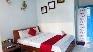 una camera con un letto con una coperta rossa e bianca di Nhà Nghỉ Mấy Kiên a Phan Thiet Altre 6 foto