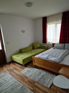 Un dormitorio con dos camas y un sofá. en Cabana Marama, en Bratca