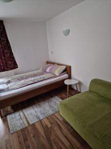Habitación con cama y sofá verde en Cabana Marama, en Bratca