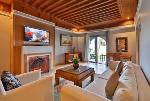 a living room with a couch and a fireplace at Pavillon du Golf - Palmeraie suites in Marrakesh