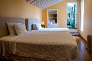 a bedroom with two beds and a window at Casa Villa Garden in Ponta Delgada