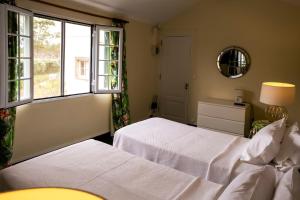 a bedroom with two beds and a window at Casa Villa Garden in Ponta Delgada