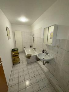 a bathroom with a sink and a tub and a toilet at Apartment Kompakt Gottschalk 3,0 in Kassel +12 photos