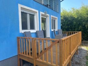 a blue house with a deck with chairs on it at Villa Plavi Lav Potok in Potok
