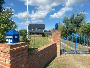 a brick fence and a blue gate with a statue at Villa Plavi Lav Potok in Potok