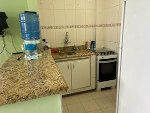 a kitchen with a bottle of water on a counter at Apto em frente ao mar prédio redondo linda vista in Peruíbe +2 photos