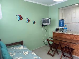 a room with a table and a tv in a room at Apto em frente ao mar prédio redondo linda vista in Peruíbe