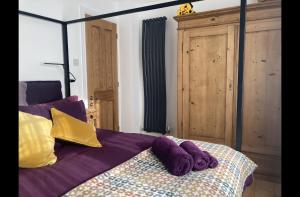 a bedroom with a bed with purple and yellow pillows at Sea Spirit Eco Guest House in Exmouth