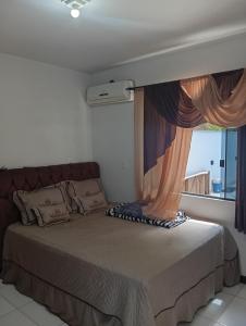 a bedroom with a large bed with a window at Casa de férias Branvek in Brusque