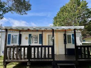 a house with a gazebo on a deck at Mobilhome Super Titania - 3 Bedrooms - Family Camping JF102 in Les Mathes