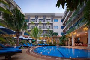 Baitong Heritage Hotel في سيام ريب: فندق به حمام سباحة أمام المبنى