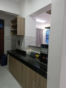 a kitchen with a black counter top and wooden cabinets at Sharz place - Mombasa in Mombasa +20 photos