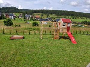 a playground in the middle of a field at Domki u seseta 2 in Kluszkowce