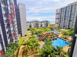 an apartment with a swimming pool and palm trees at Nature Home 3 - Swiss Garden Resort Residences - Weekend Free Breakfast in Kampung Sungai Karang