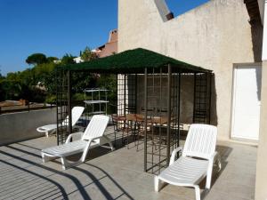 een groep stoelen en een tafel en parasol op een patio bij T3 vue mer exceptionnelle in Cassis