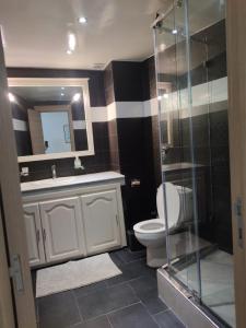 une salle de bain avec toilettes et douche en verre dans l'établissement Appartement de standing, à Casablanca